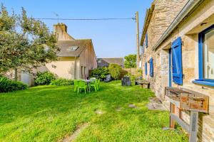 a yard with green chairs and a table at Maison 6 personnes avec piscine in Le Conquet
