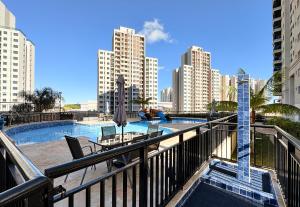 een balkon met een zwembad in een stad bij Elegante, funcional, a 5 minutos do Metrô in Brasilia