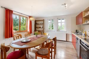 une cuisine et une salle à manger avec une table et des chaises en bois dans l'établissement Ferienwohnung Bergblick, à Veckenstedt