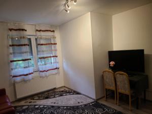 a living room with a tv and a table and two chairs at Ihr Zuhause auf Zeit in Düren - Eifel