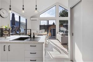 a kitchen with a sink and a living room at Amie's Charming Villa in Tauranga