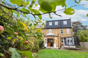 ein Backsteinhaus mit einem schwarzen Dach in der Unterkunft The Shakespeare -5Bed 3Bath in Ealing