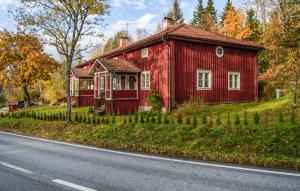 a red house sitting on the side of a road at Pet Friendly Home In Kopparberg With Lake View in Kopparberg