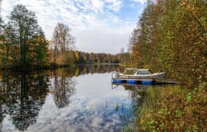a boat is docked at a dock on a lake at Pet Friendly Home In Kopparberg With Lake View in Kopparberg +6 photos