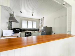 a large kitchen with a wooden counter top at Le Clos de Valletot in Valletot