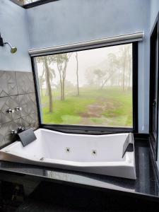 a bath tub in a bathroom with a large window at Cabanas Laurita BG in Bento Gonçalves +19 photos