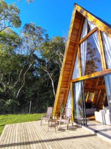 a house with two chairs on a wooden deck at CabanasLauritaBG in Bento Gonçalves