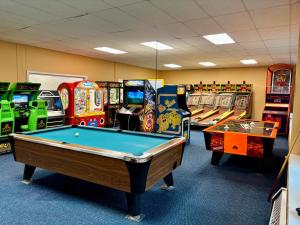 a room with several arcade games and a pool table at Loon Mountain Retreat with Pool and Hot Tub in Lincoln