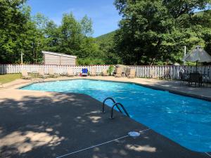 a swimming pool in a yard with a fence at Loon Mountain Retreat with Pool and Hot Tub in Lincoln