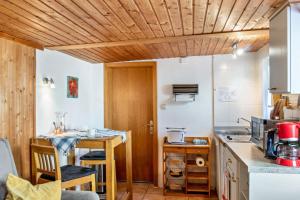 a kitchen with wooden ceilings and a table with chairs at Ferienwohnung Kleiner Strandfloh in Wangerooge
