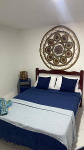 a bedroom with a blue bed with a basket on the wall at Suíte Mykonos Canoa Quebrada- Ao lado da Broadway in Aracati +7 photos