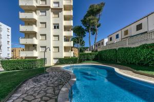 a swimming pool in front of a building at San Enrique in L'Escala