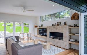 a living room with a couch and a fireplace at Crane Lodge in Whale Beach