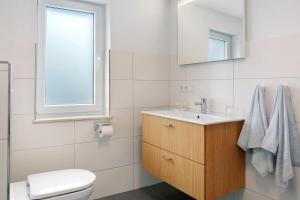 a white bathroom with a sink and a toilet at Ferienanlage Kappeln in Kopperby +13 photos