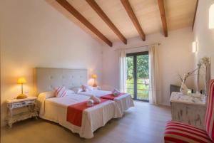 a bedroom with a large bed and a large window at S'alzinar Villa in Sa Pobla