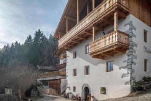 a building with a balcony on the side of it at Malsötscherhof Apt A in Villandro