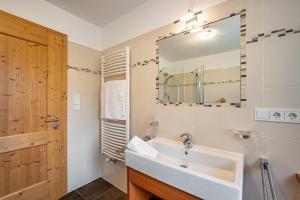 a bathroom with a sink and a mirror at Stoffnerhof Apt Sonnenblume in Tesido +36 photos
