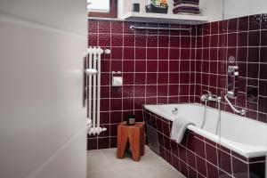 a red tiled bathroom with a tub and a sink at Casa Graf in Bad Emstal +18 photos