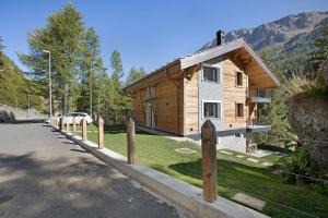 una pequeña casa de madera al costado de una carretera en Valgrisa Mountain Lodges 1, en Valgrisenche