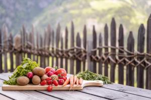 a pile of vegetables on a cutting board on a table at Tratterhof Apt Astjoch in Vandoies +27 photos