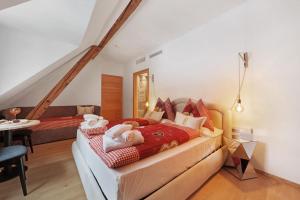 a bedroom with a bed and a table and a couch at Boutique Hotel Santer Klause in Merano