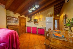 a kitchen with a wooden table and a refrigerator at Tenguerengue in Laroya