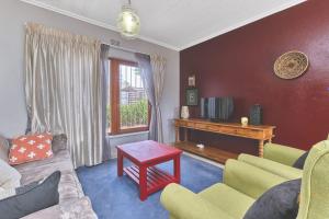 a living room with a couch and a table at The Cozy 2 bedroom Apartment in Roodepoort