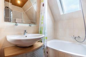a bathroom with a sink and a tub and a mirror at Ferienwohnung auf dem Land in Altenwillershagen +14 photos