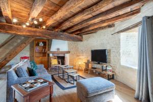 ジャール・シュル・メールにあるGîte La Tourette - Charme atypiqueのソファとテレビのあるリビングルーム