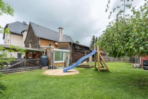 une cour avec un toboggan devant une maison dans l'établissement Chalet Kunterbunt, à Langenwetzendorf