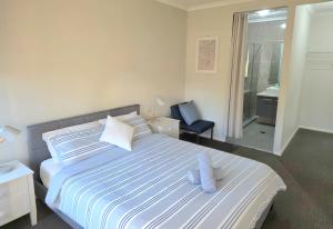 NarellanにあるGledswood Hills, The Cloverhill Charmの大きなベッドと椅子のある寝室