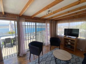a living room with a television and a table and chairs at Cabaña Vista Mar in Tongoy