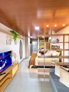 a bedroom with a bed and a tv and a couch at Flat StudioMar - beira mar até 4 p - pé na areia in Coruripe