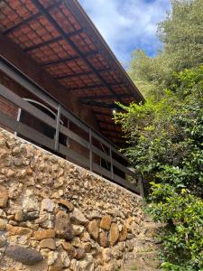a stone retaining wall next to a building at Espaço Riacho in Nova Friburgo +50 photos