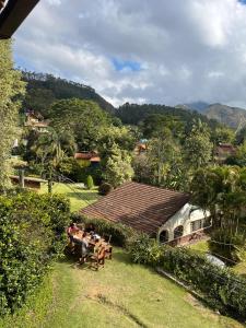 a group of people sitting at a table in a yard at Espaço Riacho in Nova Friburgo