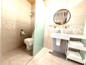 a bathroom with a sink and a mirror and a toilet at 看海季節&聽海約定精緻旅店 in Magong