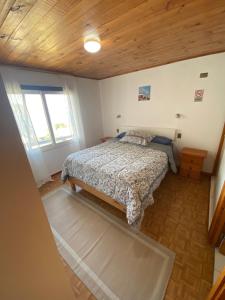 a bedroom with a bed and a wooden ceiling at Cabaña Vista Mar in Tongoy