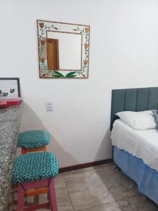 a bedroom with a bed and a mirror on the wall at Flat Lua Nova - Pituba I coração da vila e caminho praias in Itacaré