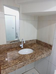 a bathroom counter with a sink and a mirror at Flat Lua Nova - Pituba I coração da vila e caminho praias in Itacaré +16 photos