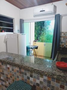 a kitchen with a counter top in a room at Flat Lua Nova - Pituba I coração da vila e caminho praias in Itacaré
