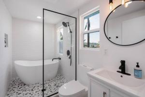 a bathroom with a tub and a toilet and a sink at Hillside House with DTLA Views in Los Angeles