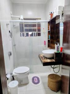 een witte badkamer met een toilet en een wastafel bij Casa Cantinho no Litoral in São Sebastião +50 foto's