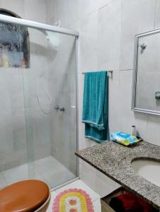 ein Badezimmer mit Dusche, Toilette und Waschbecken in der Unterkunft Casa Cantinho no Litoral in São Sebastião