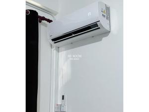 a white air fryer hanging on a wall at My Room Sri Aman in Kampong Lamanak