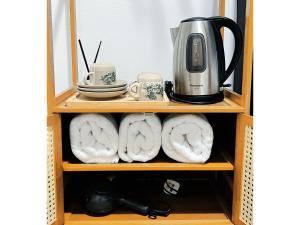 a shelf with towels and a coffee maker on it at My Room Sri Aman in Kampong Lamanak