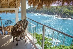a balcony with chairs and a view of the ocean at casa wow in Puerto Ángel