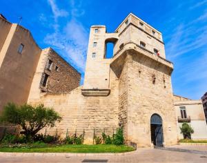 an old stone building with a large tower at T2 Avec Jacuzzi En Face de l'Arc de Triomphe B in Montpellier