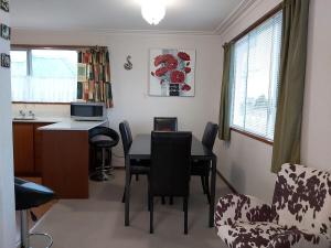 eine Küche und ein Esszimmer mit Tisch und Stühlen in der Unterkunft Beachside Townhouse Dunedin in Dunedin + 5 Fotos