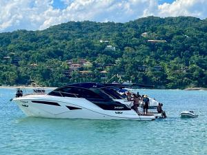 un groupe de personnes sur un bateau dans l'eau dans l'établissement Apartamento Impecável Completo próximo à praia com Barco Opcional, à Guarujá