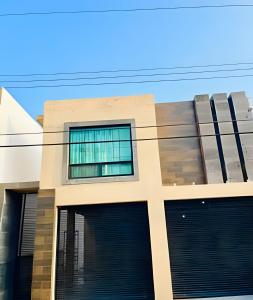 a building with two garage doors in front of it at Casa Exclusiva/15 PX/Parkin/Wifi in Reynosa